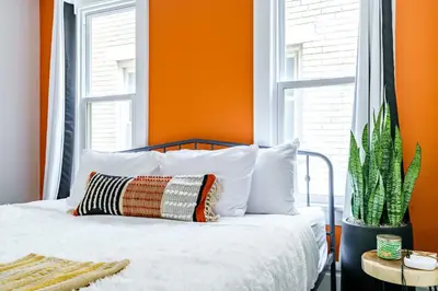 an orange bedroom with a bed and a cactus at Jungle House Luxury Stays - Columbus Downtown Short North in Columbus