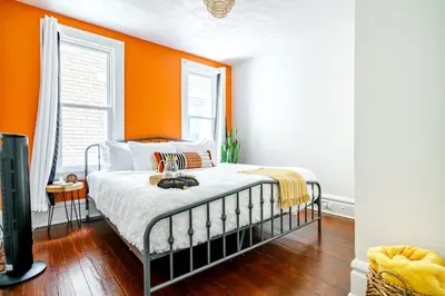 a bedroom with an orange wall and a bed at Jungle House Luxury Stays - Columbus Downtown Short North in Columbus