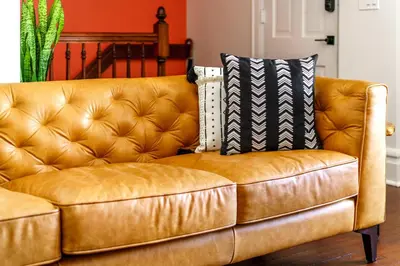 a brown leather couch with two pillows on it at Jungle House Luxury Homes - Columbus Downtown Short North - Walk to Convention Center & Nationwide Arena - Sleeps up to 8 - Free Parking - Over 5,800 Five Stars in Columbus