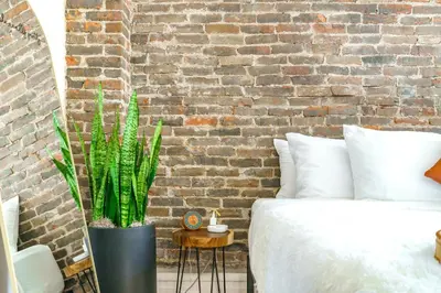 a bedroom with a bed and a brick wall at Jungle House Luxury Homes - Columbus Downtown Short North - Walk to Convention Center & Nationwide Arena - Sleeps up to 8 - Free Parking - Over 5,800 Five Stars in Columbus
