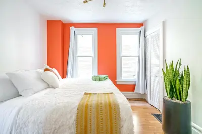 a bedroom with an orange wall and a bed at Jungle House Luxury Homes - Columbus Downtown Short North - Walk to Convention Center & Nationwide Arena - Sleeps up to 8 - Free Parking - Over 5,800 Five Stars in Columbus