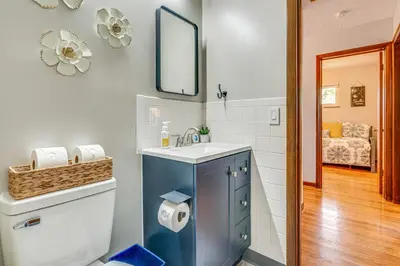 a bathroom with a sink and a toilet with a mirror at 7 Mi to Downtown Columbus Family Getaway with Yard in Columbus
