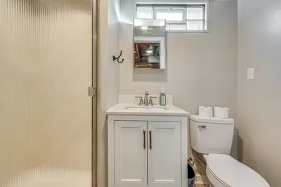 a white bathroom with a toilet and a sink at 7 Mi to Downtown Columbus Family Getaway with Yard in Columbus