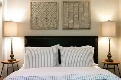 a bedroom with a large bed with two lamps at The Knocking Bird- Mins to CLE Clinic in Cleveland Heights