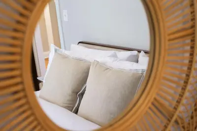 a reflection of a bed with pillows in a mirror at The Knocking Bird- Mins to CLE Clinic in Cleveland Heights