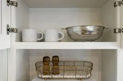 a shelf with cups and a basket on it at The Knocking Bird- Mins to CLE Clinic in Cleveland Heights
