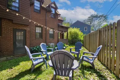 a yard with chairs and a table and a fence at The Knocking Bird- Mins to CLE Clinic in Cleveland Heights