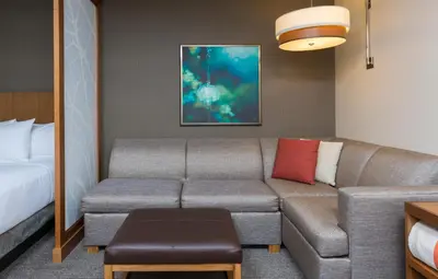 a living room with a couch and a bed at Hyatt Place Canton in Lake Cable