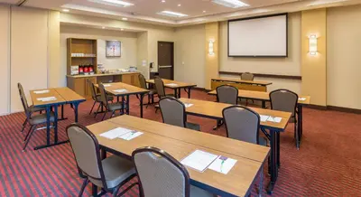 a classroom with wooden tables and chairs and a screen at Hyatt Place Canton in Lake Cable