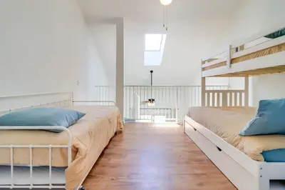 a bedroom with two beds and a staircase at 13 Mi to Port Clinton Lake Erie Getaway with Dock in Oak Harbor