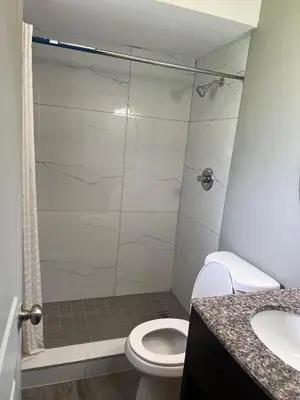 a bathroom with a shower with a toilet and a sink at Red Carpet Inn in Garfield Heights