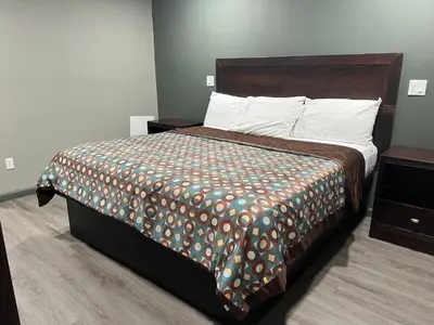 a bedroom with a large bed with a comforter at Red Carpet Inn in Garfield Heights