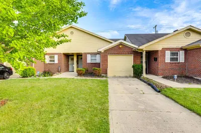a brick house with a yellow garage at 4 Mi to Dtwn Dayton Convenient Condo with Grill in Dayton