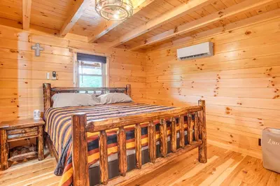 a bedroom with a bed in a log cabin at Chillicothe Cabin Near Hocking Hills State Park! in Chillicothe