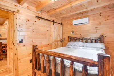 a bedroom with a bed in a log cabin at Chillicothe Cabin Near Hocking Hills State Park! in Chillicothe