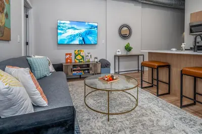 a living room with a couch and a table at Prime OTR, 3 Lux Queen Beds, Two 55in TVs, Steps to TQL, Findlay Market, Light Rail, Fast Wifi in Cincinnati