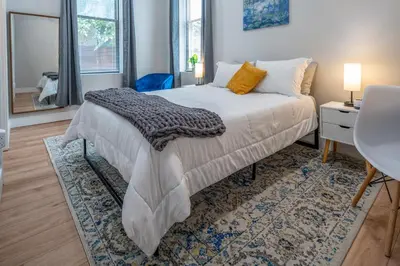 a bedroom with a bed and a table and a desk at Prime OTR, 3 Lux Queen Beds, Two 55in TVs, Steps to TQL, Findlay Market, Light Rail, Fast Wifi in Cincinnati