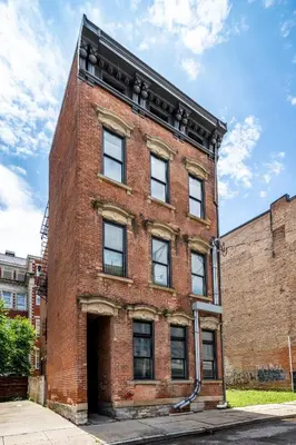 a red brick building with a door on it at Prime OTR, 3 Lux Queen Beds, Two 55in TVs, Steps to TQL, Findlay Market, Light Rail, Fast Wifi in Cincinnati