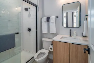 a bathroom with a toilet and a sink and a shower at Prime OTR, 3 Lux Queen Beds, Two 55in TVs, Steps to TQL, Findlay Market, Light Rail, Fast Wifi in Cincinnati