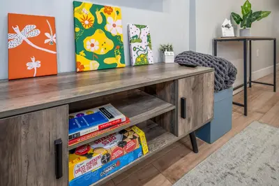 a wooden desk with a chair in a room at Prime OTR, 3 Lux Queen Beds, Two 55in TVs, Steps to TQL, Findlay Market, Light Rail, Fast Wifi in Cincinnati