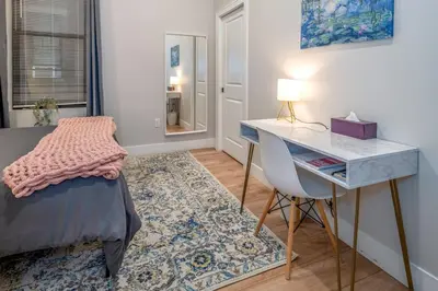 a bedroom with a desk and a bed and a table at Central Over-the-Rhine, 3 Lux Queen Beds, Steps to TQL, Findlay Market & Light Rail, Fast Wifi, Sleeps 7ppl in Cincinnati