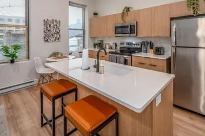 a kitchen with a white counter top and a refrigerator at Central Over-the-Rhine, 3 Lux Queen Beds, Steps to TQL, Findlay Market & Light Rail, Fast Wifi, Sleeps 7ppl in Cincinnati