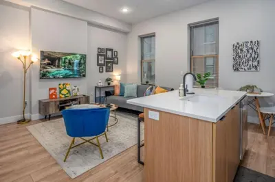 a kitchen with a sink and a living room at Central Over-the-Rhine, 3 Lux Queen Beds, Steps to TQL, Findlay Market & Light Rail, Fast Wifi, Sleeps 7ppl in Cincinnati