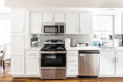 a kitchen with white cabinets and a stove and microwave at Luxury Downtown Townhome Private Garage Unit 16 in Cleveland