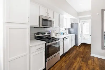 a kitchen with white cabinets and a stove top oven at Luxury Downtown Townhome Private Garage Unit 16 in Cleveland