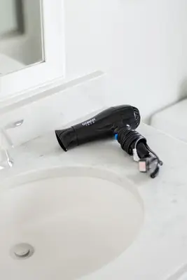 a black hair dryer sitting on a bathroom sink at Luxury Downtown Townhome Private Garage Unit 9 in Cleveland