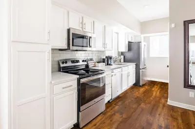 a white kitchen with a stove and a refrigerator at Luxury Downtown Townhome Private Garage Unit 9 in Cleveland