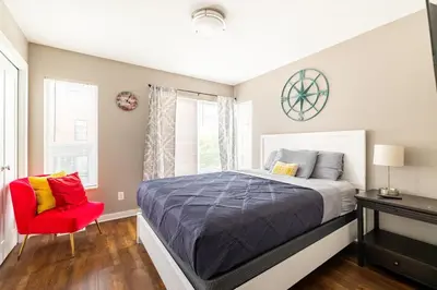 a bedroom with a bed and a red chair at Luxury Downtown Townhome Private Garage Unit 9 in Cleveland