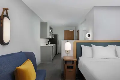 a bedroom with a bed and a couch and a kitchen at Homewood Suites By Hilton Newport Cincinnati in Newport
