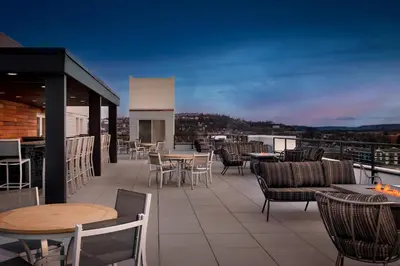 a patio with tables and chairs on a roof at Homewood Suites By Hilton Newport Cincinnati in Newport