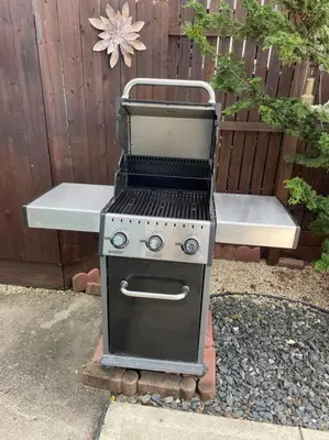 a grill sitting in a yard next to a bench at Charming Victorian Home - 2 minutes to downtown in Lancaster