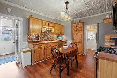 a kitchen with wooden cabinets and a table with chairs at Charming Victorian Home - 2 minutes to downtown in Lancaster