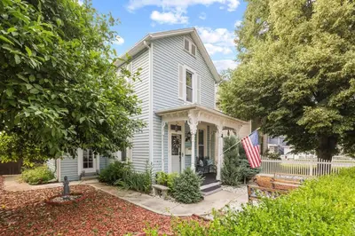 a white house with a flag in front of it at Charming Victorian Home - 2 minutes to downtown in Lancaster