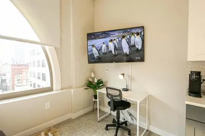a room with a desk and a tv on the wall at Bengals Paycor Reds 6 min Walk Free Parking in Cincinnati