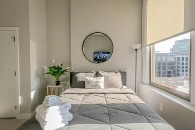 a bedroom with a bed with a mirror and a window at Bengals Paycor Reds 6 min Walk Free Parking in Cincinnati