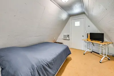 a bedroom with a bed and a desk with a computer at 5 Mi to Cave Run Lake Wellington Cabin with Deck! in Wellington