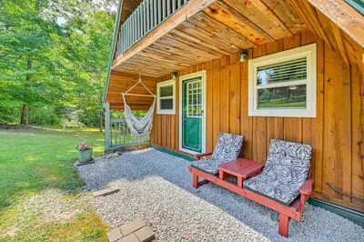 a cabin with two chairs and a bench on the porch at 5 Mi to Cave Run Lake Wellington Cabin with Deck! in Wellington