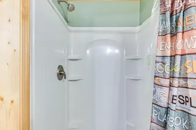 a bathroom with a white door with a shower curtain at 5 Mi to Cave Run Lake Wellington Cabin with Deck! in Wellington
