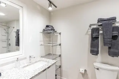 a white bathroom with a sink and a mirror at 2 Studios apartment w prime location in Cleveland