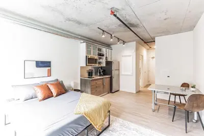 a bedroom with a bed and a desk and a kitchen at 2 Studios apartment w prime location in Cleveland