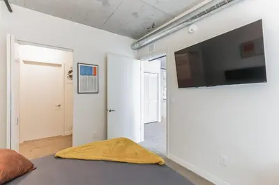 a living room with a flat screen tv on a wall at 2 Brand new apartments with city views in Cleveland