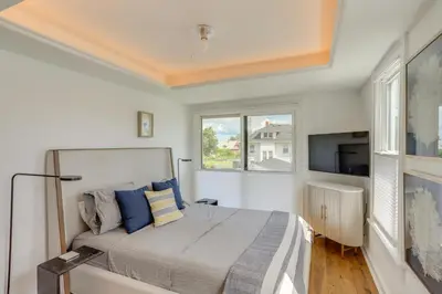 a bedroom with a bed with blue pillows and a tv at Port Clinton Home with Lake View - Walk to Beach! in Port Clinton