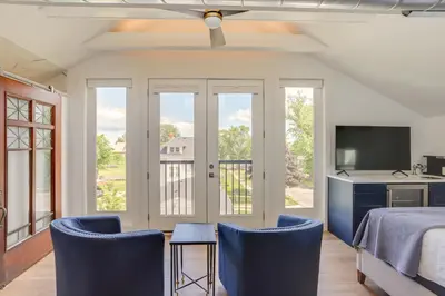 a bedroom with a bed and two chairs and a tv at Port Clinton Home with Lake View - Walk to Beach! in Port Clinton