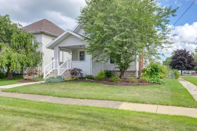 a white house with a tree in the yard at Port Clinton Home with Lake View - Walk to Beach! in Port Clinton
