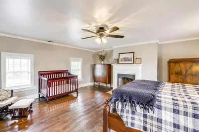 a bedroom with a crib and a ceiling fan at Vineyard Retreat at George Vest Historical Home in Verona