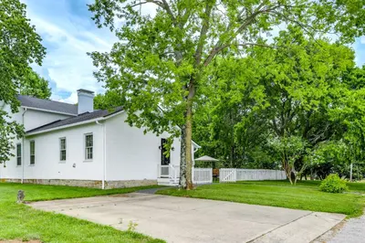 a white house with a tree in the yard at Vineyard Retreat at George Vest Historical Home in Verona
